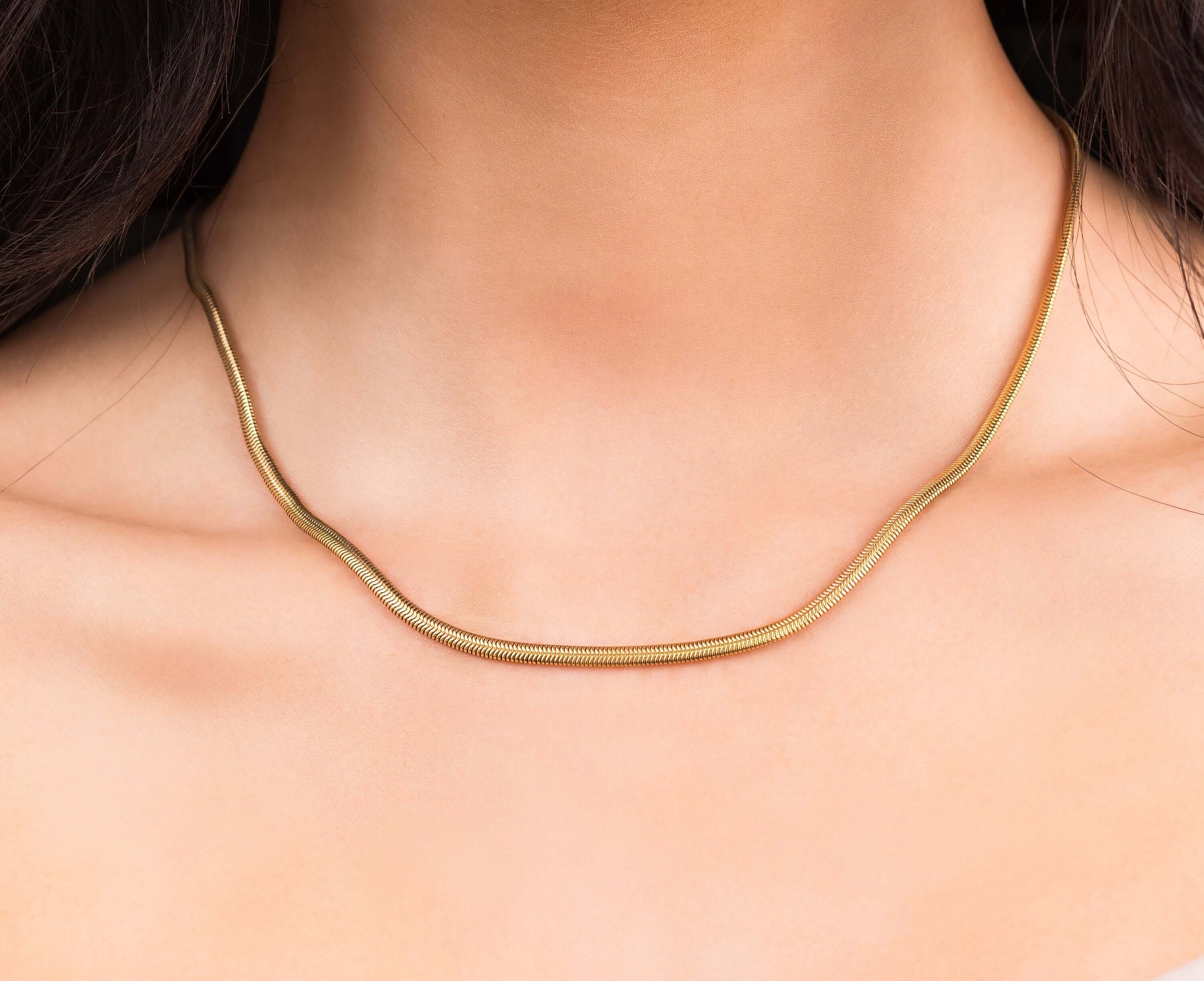 Elegant Alina Gold Herringbone Necklace worn, featuring smooth gold-plated stainless steel with a refined design.