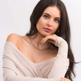 Model showcasing the Alina Gold Herringbone Necklace, exuding elegance with a silky soft finish in natural lighting.