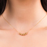 Close-up of Noura Gold Beaded Detail Necklace with five gold beads on a delicate chain, showcasing simple elegance.