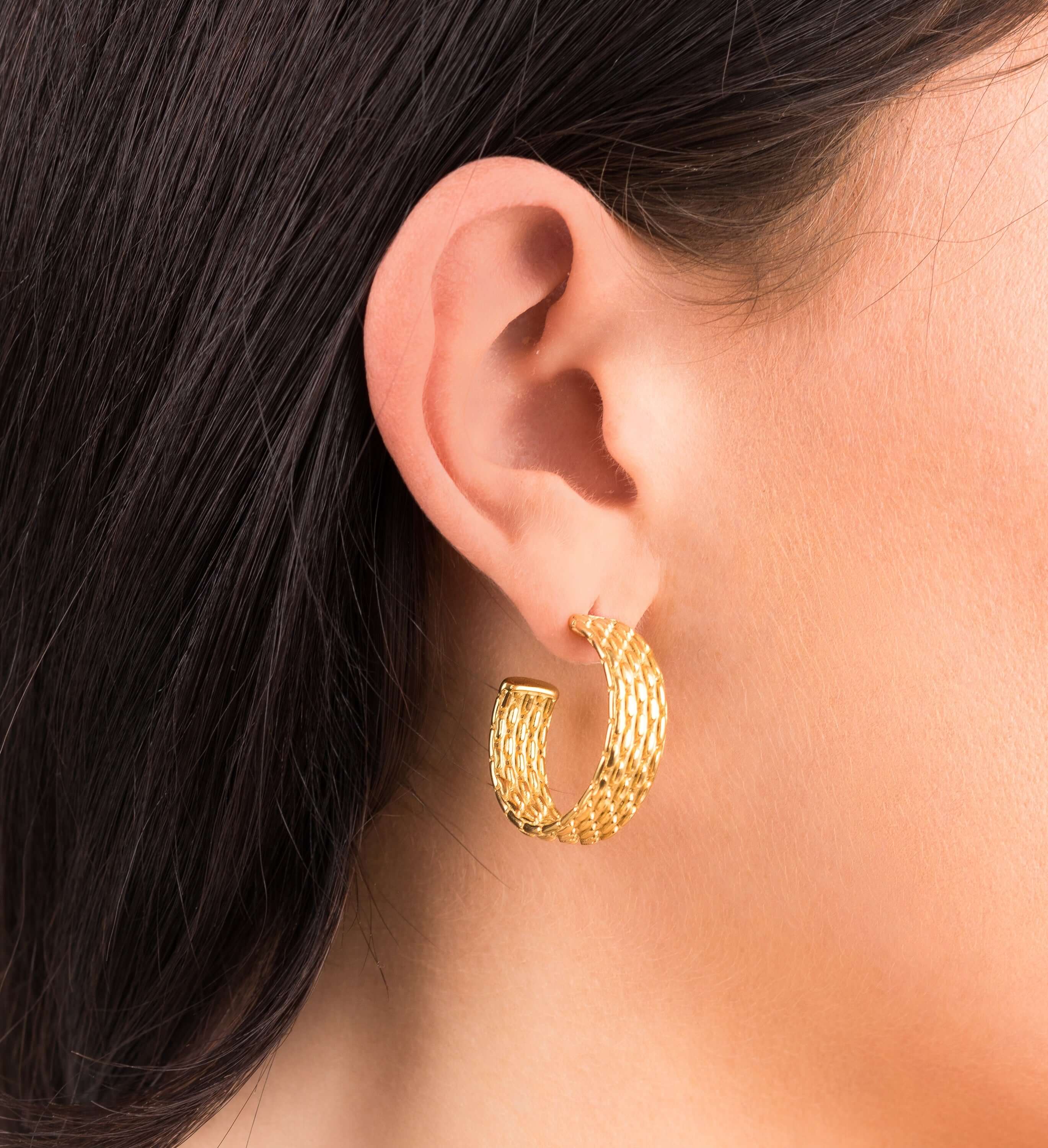 Lyra Gold Textured Hoop Earrings worn on ear, showcasing intricate woven design and modern elegance by ARIIRA.