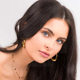 Model wearing the Isla Gold Circle Drop Necklace and circular gold hoop earrings, showcasing elegant jewelry style.