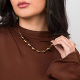 Model wearing Andrea Sculpted Teardrop Link Gold Necklace by ARIIRA with elegant teardrop shapes and smooth finish.