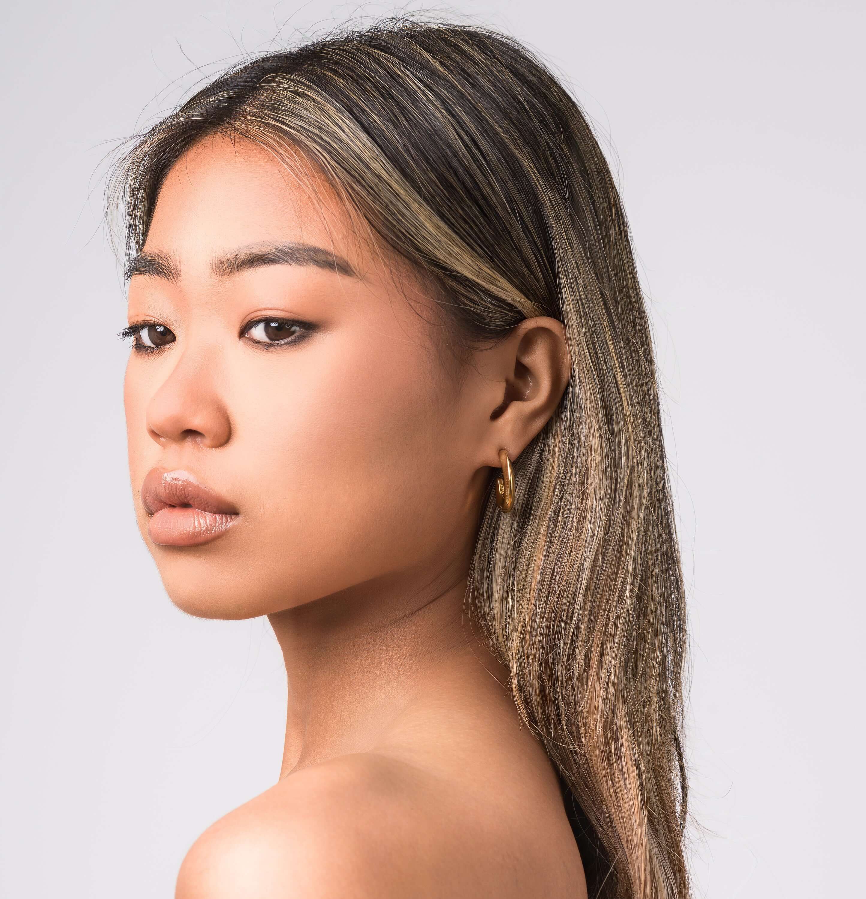 Model showcasing Lana Crescent Drop Earrings with a soft curve and high-shine finish against a neutral background.