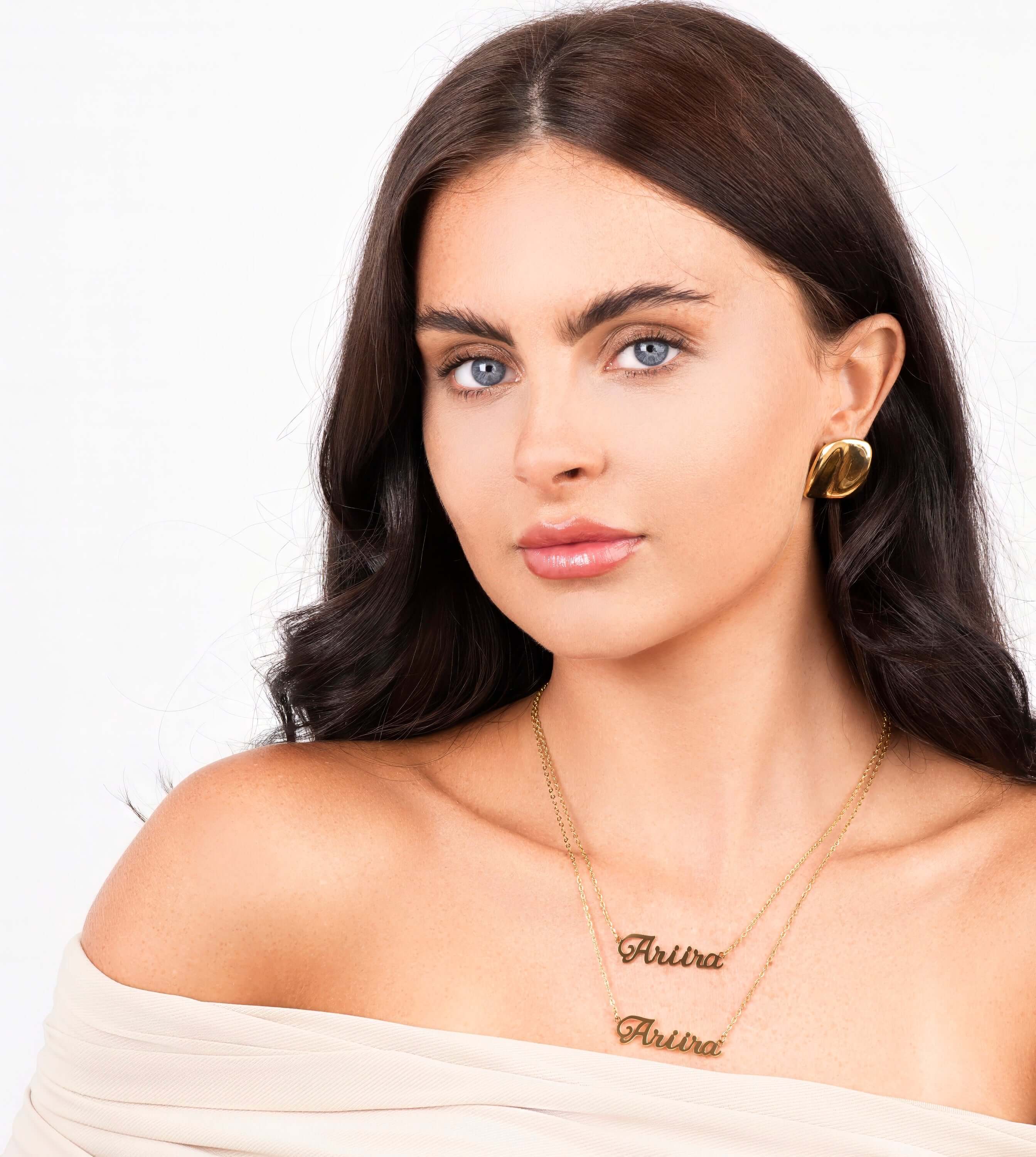 Elegant woman wearing Ediza double layer name necklace with gold finish, featuring 'Ariira' in stylish fonts.