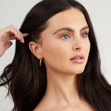 Model wearing Mila Twisted Hoop Earrings, showcasing elegant gold-plated design and sophisticated style.