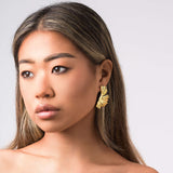 Model wearing ARIIRA Lyra Sculpted Petal Earrings, showcasing elegant, golden, floral-inspired design.
