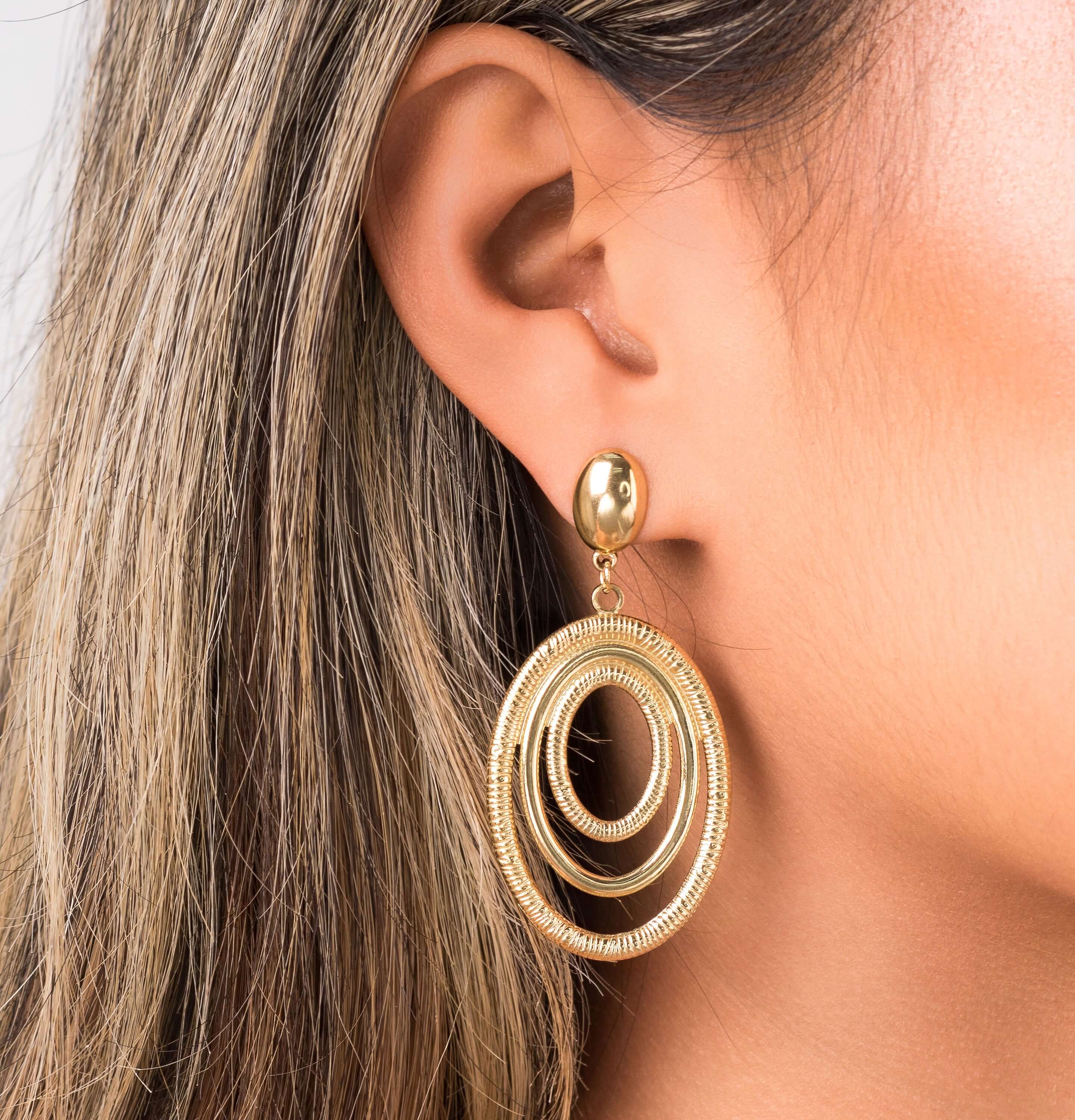Elena Orbit Drop Earrings by ARIIRA showcasing sculptural gold curves for a modern and elegant look.