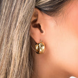 Chunky gold hoop earrings by ARIIRA showcased on model, highlighting their smooth, polished design and lightweight elegance.