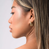 Profile view of a model wearing ARIIRA Dalia Crystal Lattice Hoop Earrings, showcasing gold latticework and sparkling crystals.