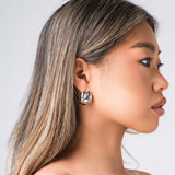 Model wearing ARIIRA Lyra Sculpted Mini Hoops, showcasing their smooth curves and modern design.