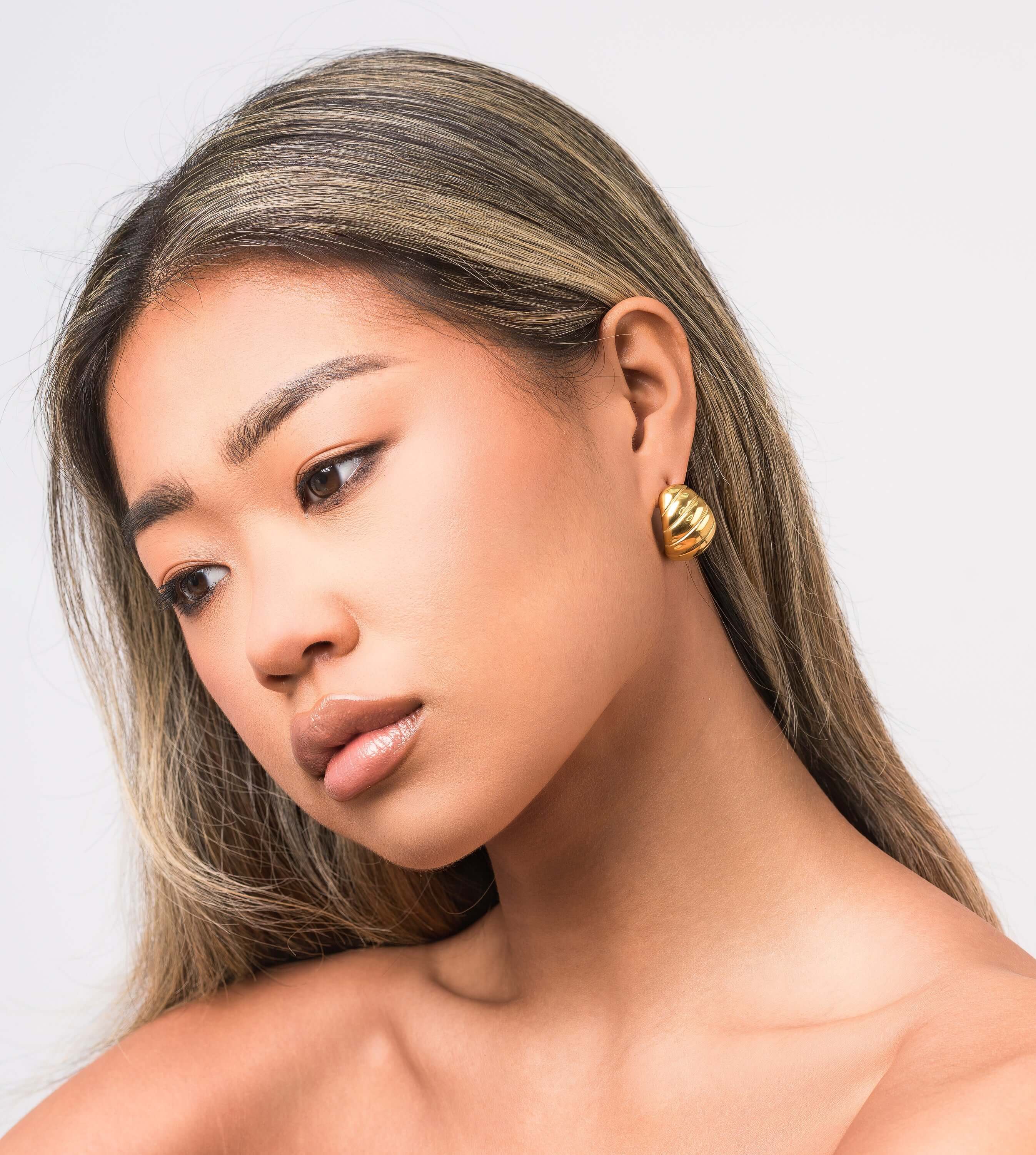 Saira Ribbed Dome Stud Earrings by ARIIRA, showcasing a lightweight and polished gold design for effortless style.