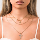 Nour Layered Sun & Cross Necklace Set from ARIIRA featuring three unique chains and elegant charms.
