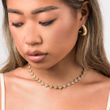 Close-up of a woman wearing the Lina Crystal Flower Link Necklace by ARIIRA, featuring delicate crystal flowers.