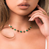 ARIIRA Soraya Enamel Clover Link Necklace featuring green enamel and gold-tone clover links on a model.