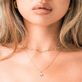 Leonora Layered Chain Necklace by ARIIRA featuring a solitaire charm and a delicate, radiant design.
