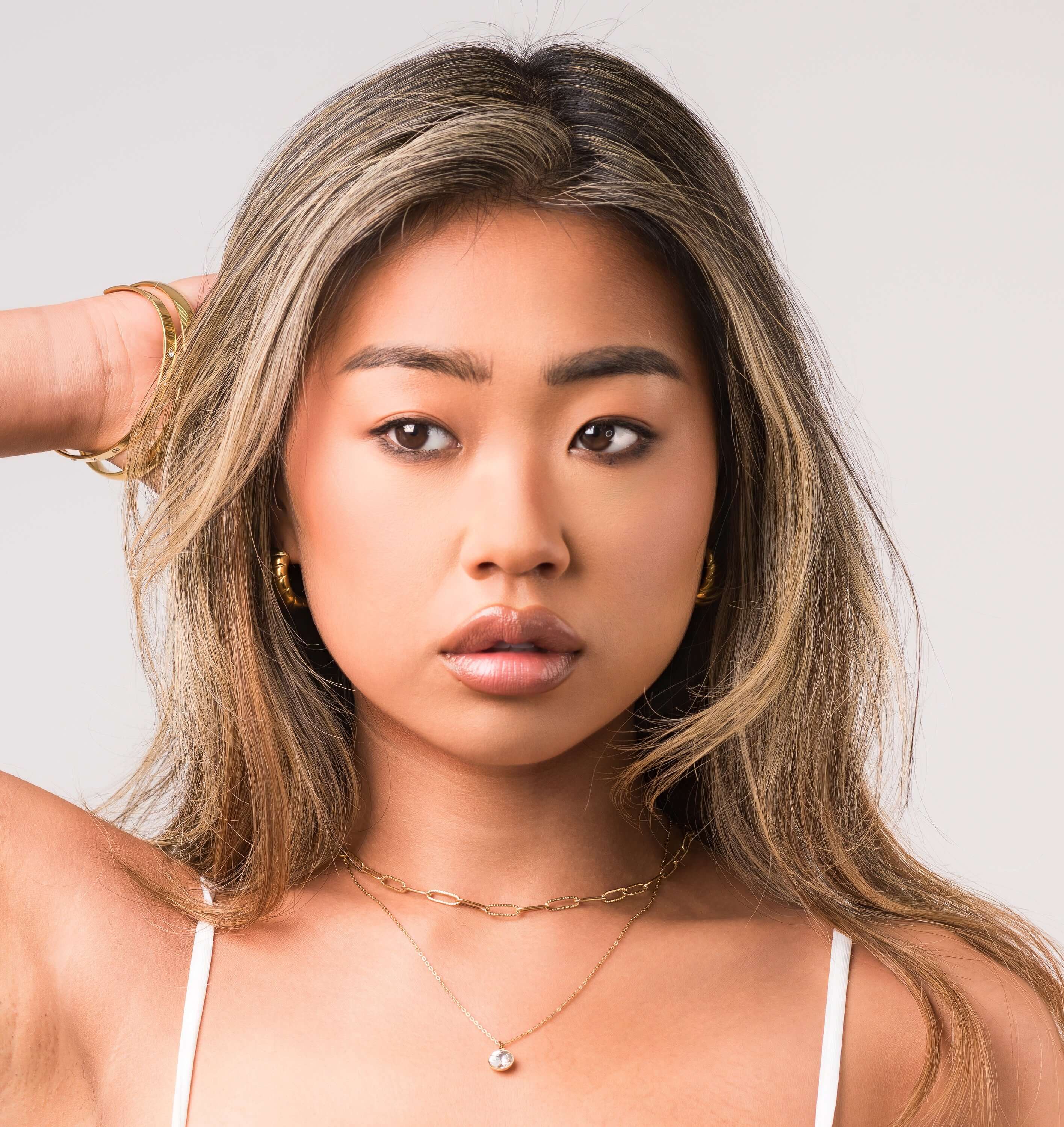 ARIIRA Leonora layered chain necklace on model, featuring a solitaire charm and elegant link design.