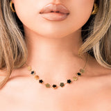Woman wearing ARIIRA Soraya Enamel Clover Link Necklace with smooth enamel and gold-tone clover links.