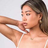 Model showcasing ARIIRA Reina Roman Circle Pendant Necklace, highlighting its elegance and minimalist design.