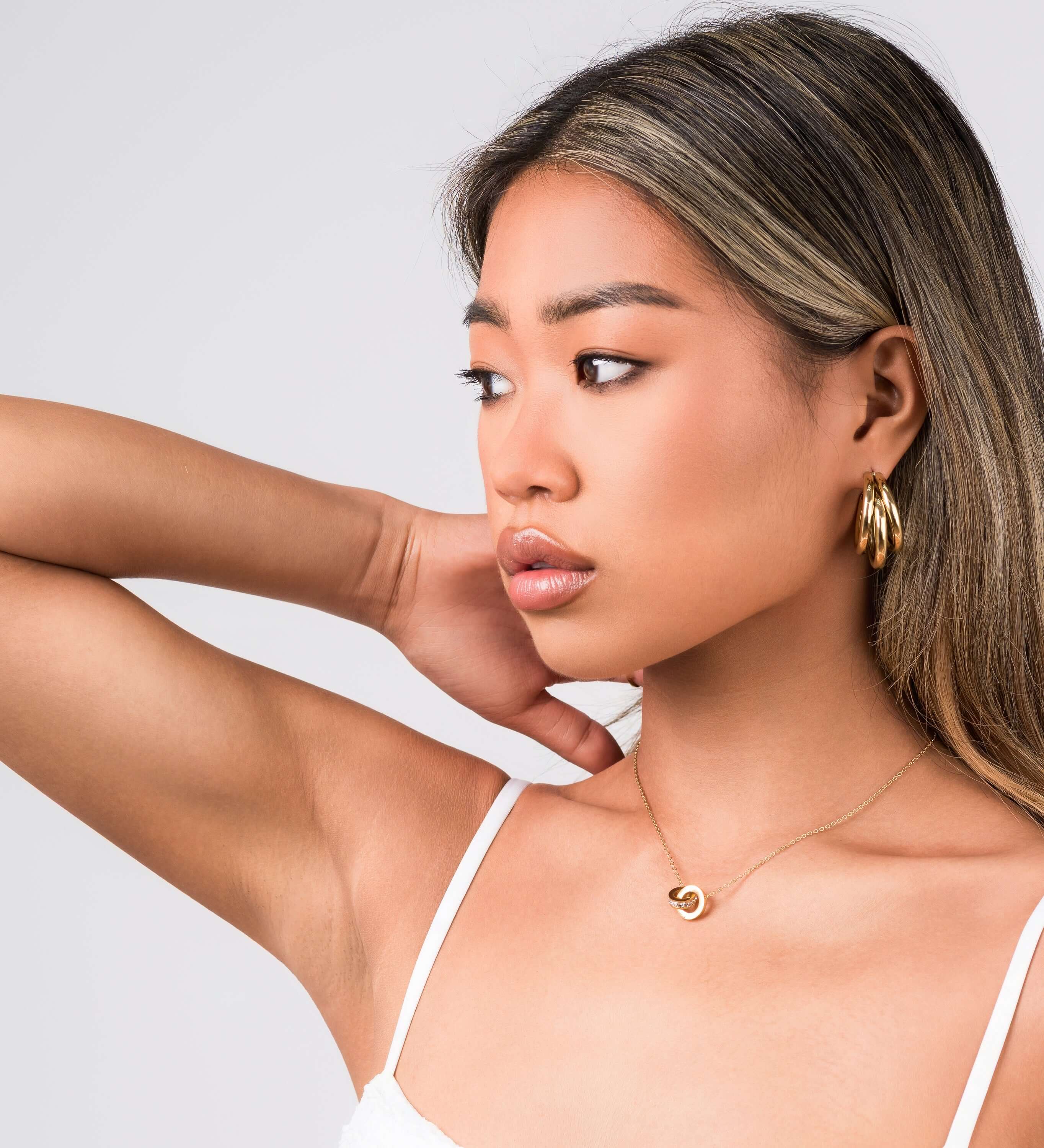 Model showcasing ARIIRA Reina Roman Circle Pendant Necklace, highlighting its elegance and minimalist design.
