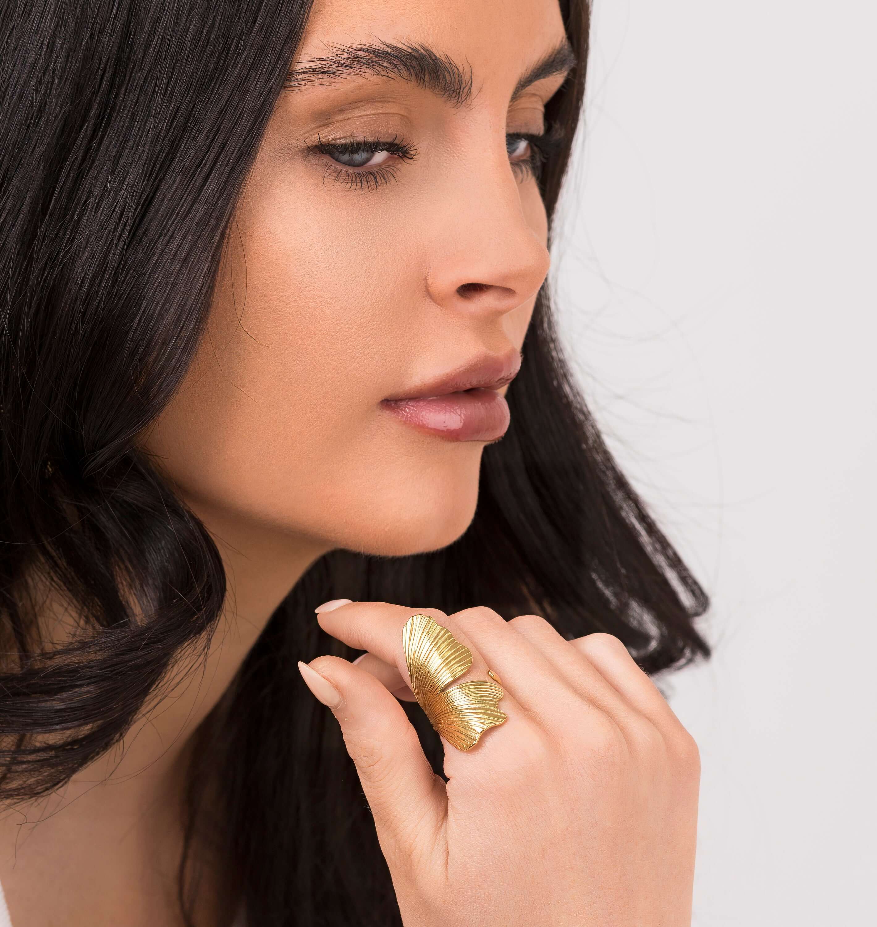 Elegant woman wearing ARIIRA's Aria winged textured adjustable ring, showcasing its delicate gold design.