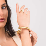 Iyla Flexible Ribbed Open Gold Bangle showcasing fluid coil texture on a model's wrist.