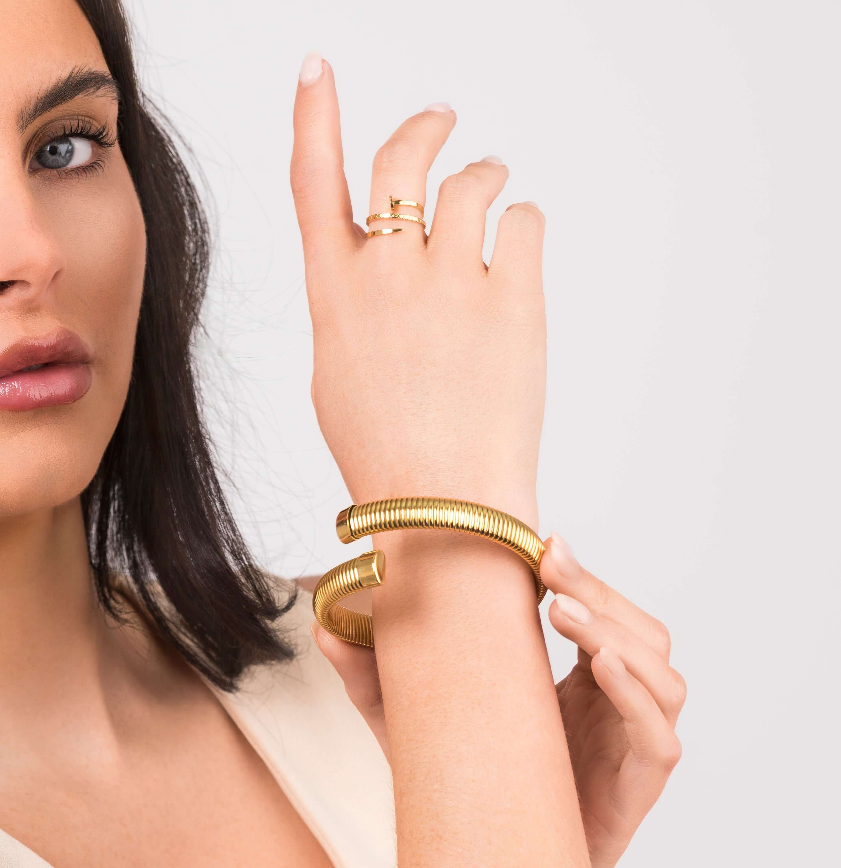 Iyla Flexible Ribbed Open Gold Bangle showcasing fluid coil texture on a model's wrist.