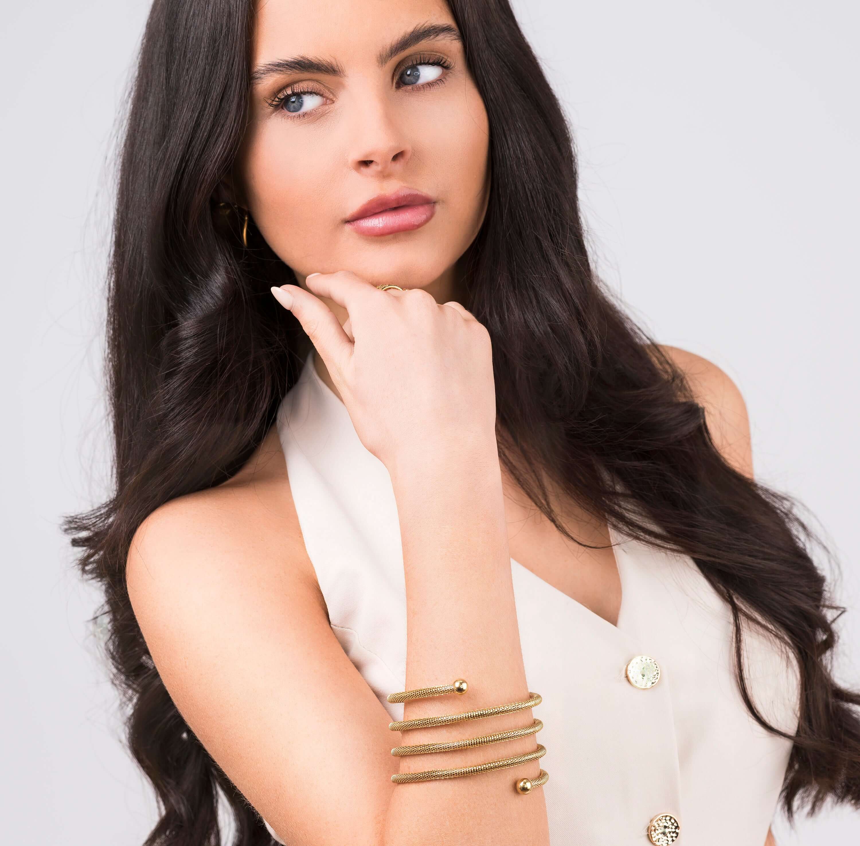 Model showcasing the ARIIRA Zina Spiral Mesh Coil Bracelet, featuring a soft spiral design and polished end spheres.