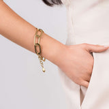 Gold geometric chunky link chain bracelet by ARIIRA worn on a woman's wrist, showcasing modern elegance.