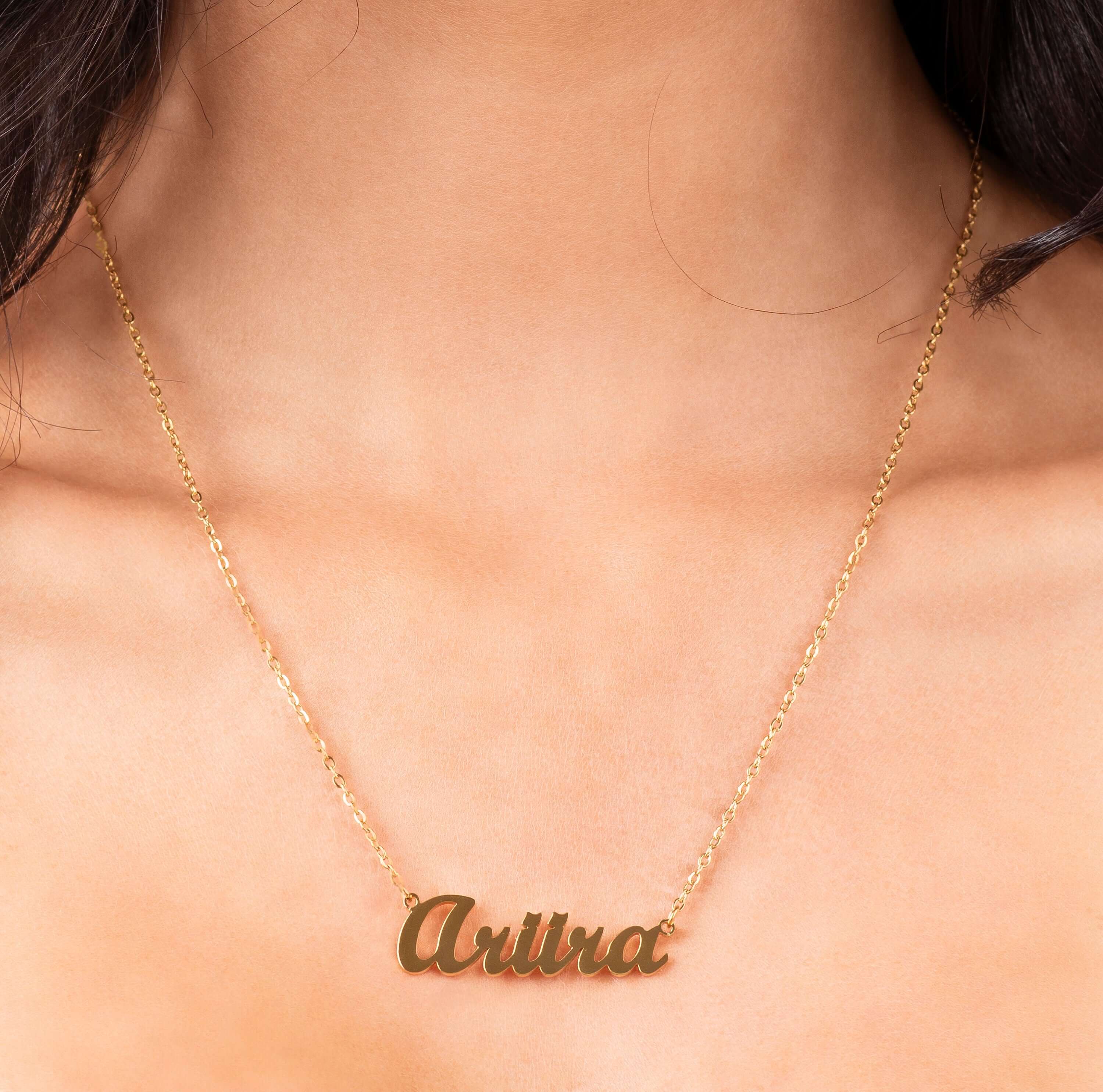 Personalised gold name necklace reading 'Ariira' in bold cursive, a delicate custom jewellery piece.