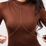 Model wearing the Athena Minimal Gold Body Chain by ARIIRA, featuring bar details on a brown top.