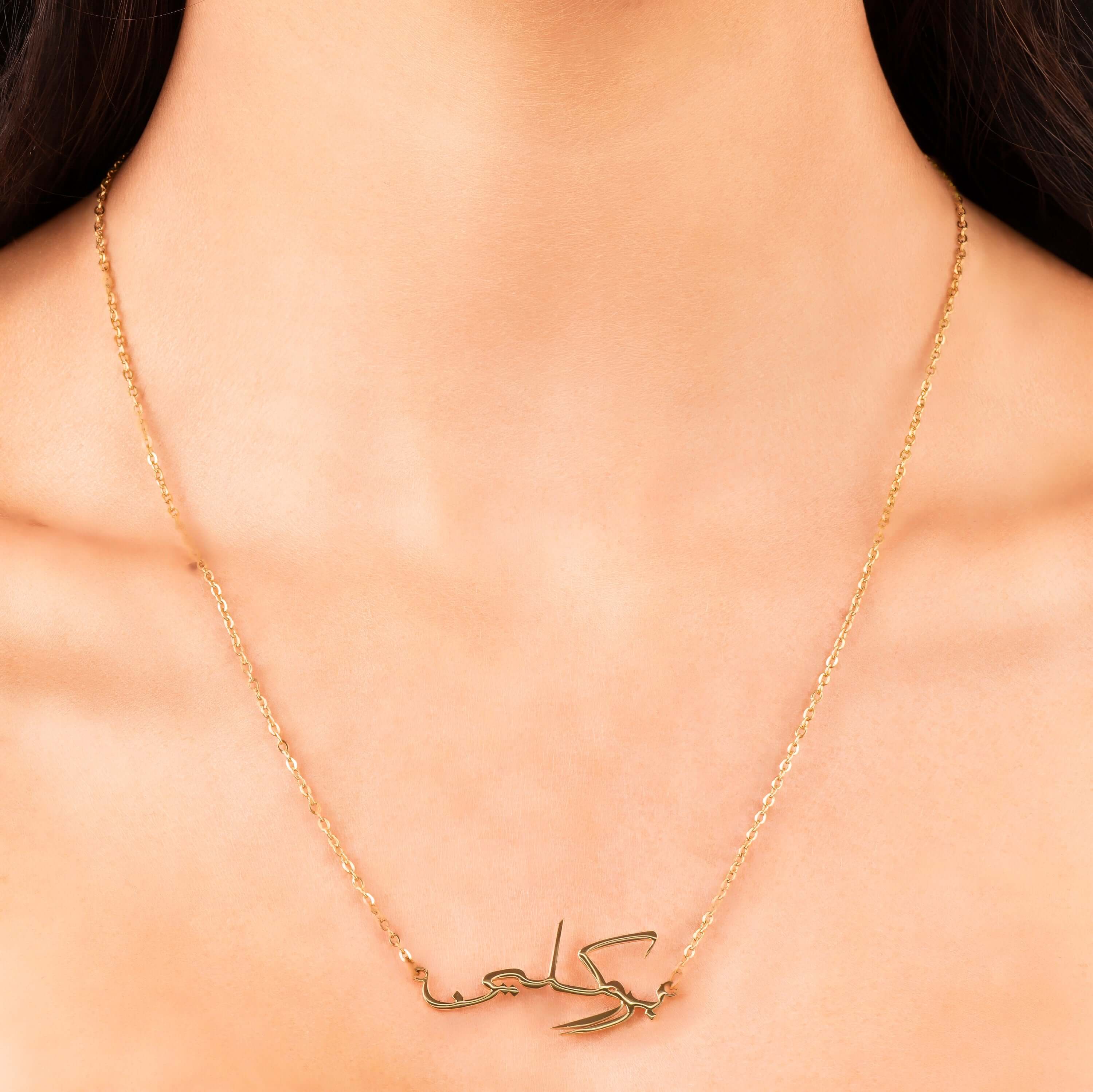 Dahlia Arabic Script custom name necklace with ARIIRA in polished calligraphy, elegantly worn close to the collarbone.