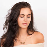 Ayla Custom Name Necklace in gold, featuring the name 'ARIIRA' worn by a model with flowing hair.