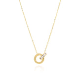 Reina Roman Circle Pendant Necklace by ARIIRA, featuring a polished circle with Roman numerals and a crystal charm.