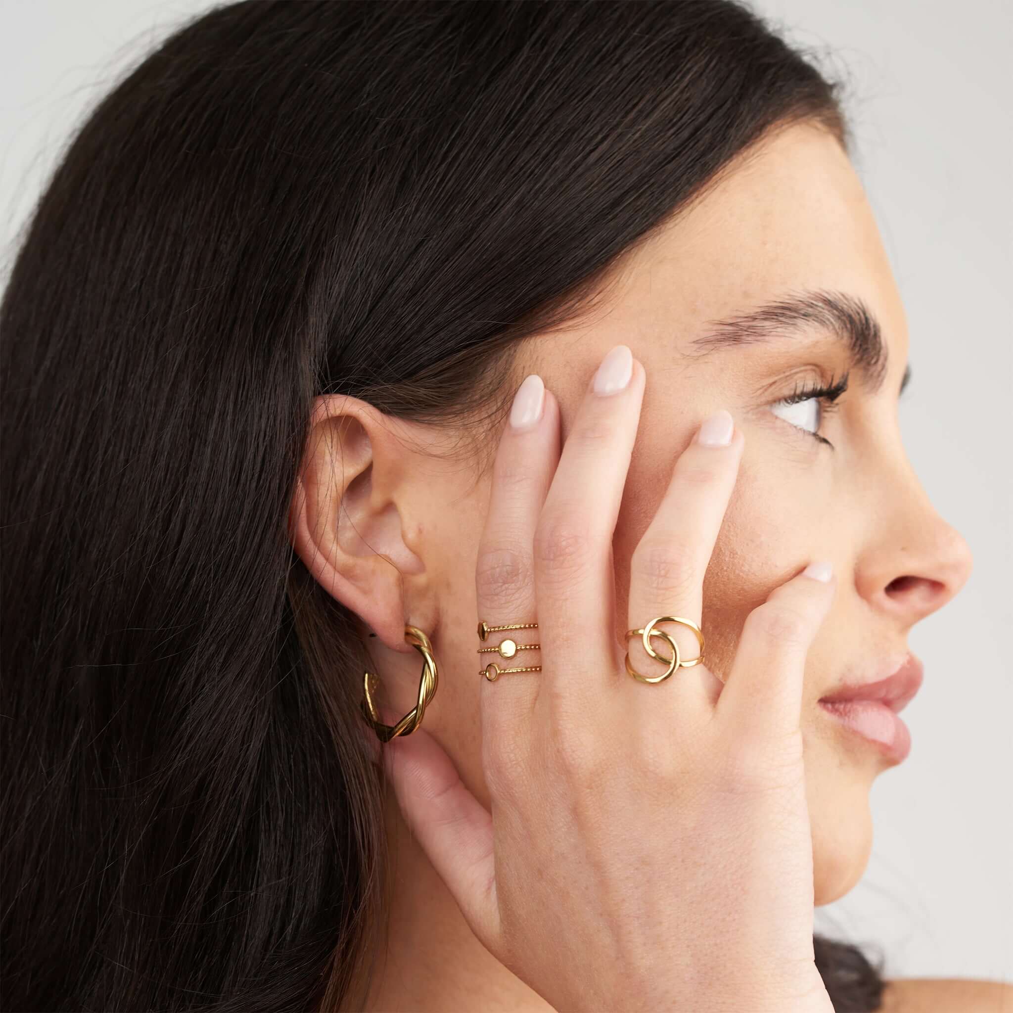 Model showcasing ARIIRA Lyla Orbit Open Ring with delicate gold jewelry against a neutral background.