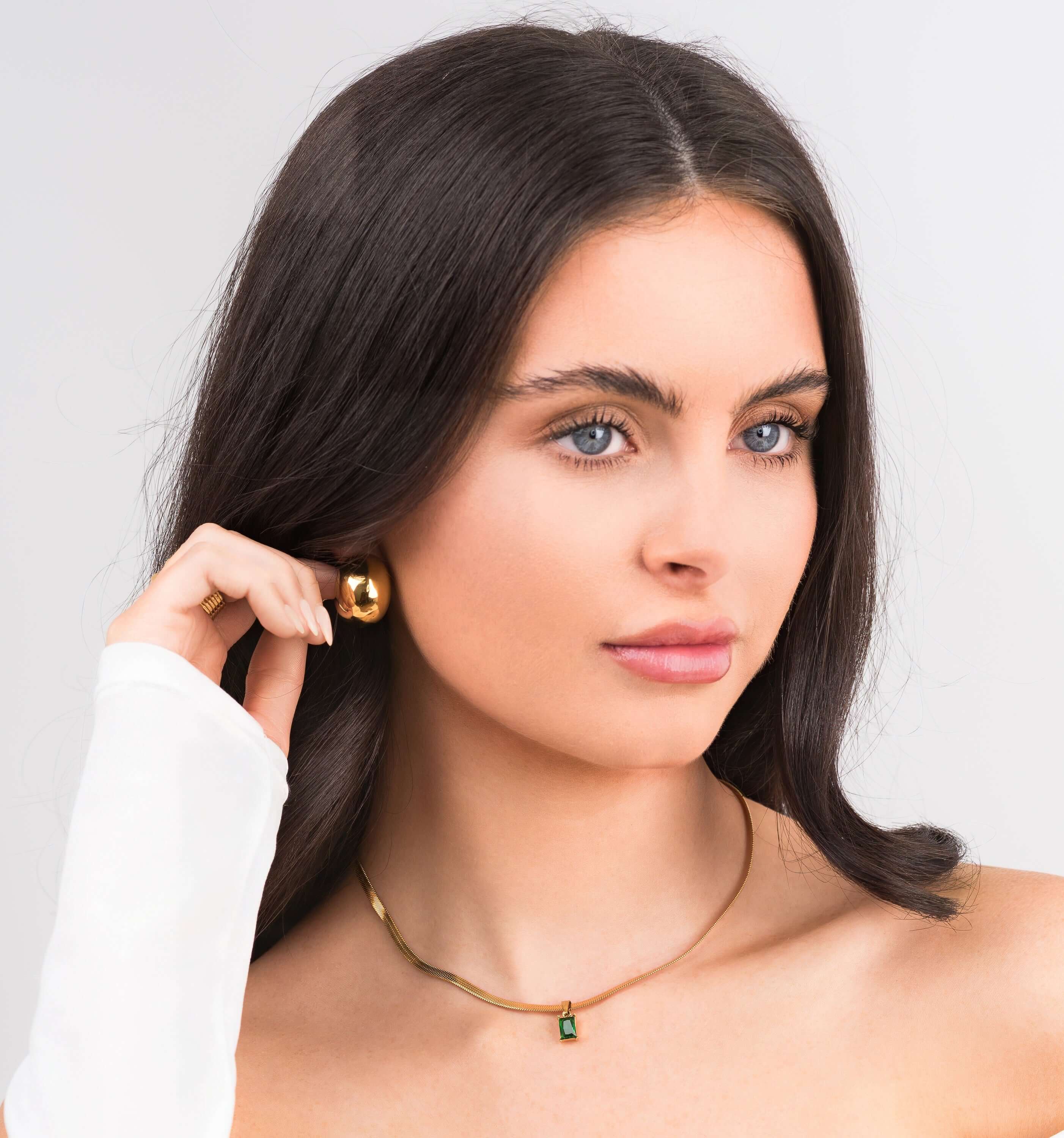 Model wearing ARIIRA Emerald Green Gemstone Necklace in gold, showcasing elegance and modern minimalism.