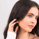 Model wearing ARIIRA Sana Gold Sculpted Dome Earrings, showcasing elegant gold-plated studs with a modern silhouette.