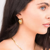 Sana Gold Sculpted Dome Earrings worn by a model, showcasing their polished gold finish and elegant design.