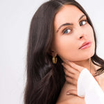 Model showcasing ARIIRA Elise Gold Teardrop Hoop Earrings, highlighting their sculptural design and high-shine finish.