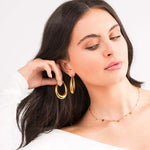 Model wearing Elise Gold Teardrop Hoop Earrings by ARIIRA, showcasing their elegant design and high-shine finish.
