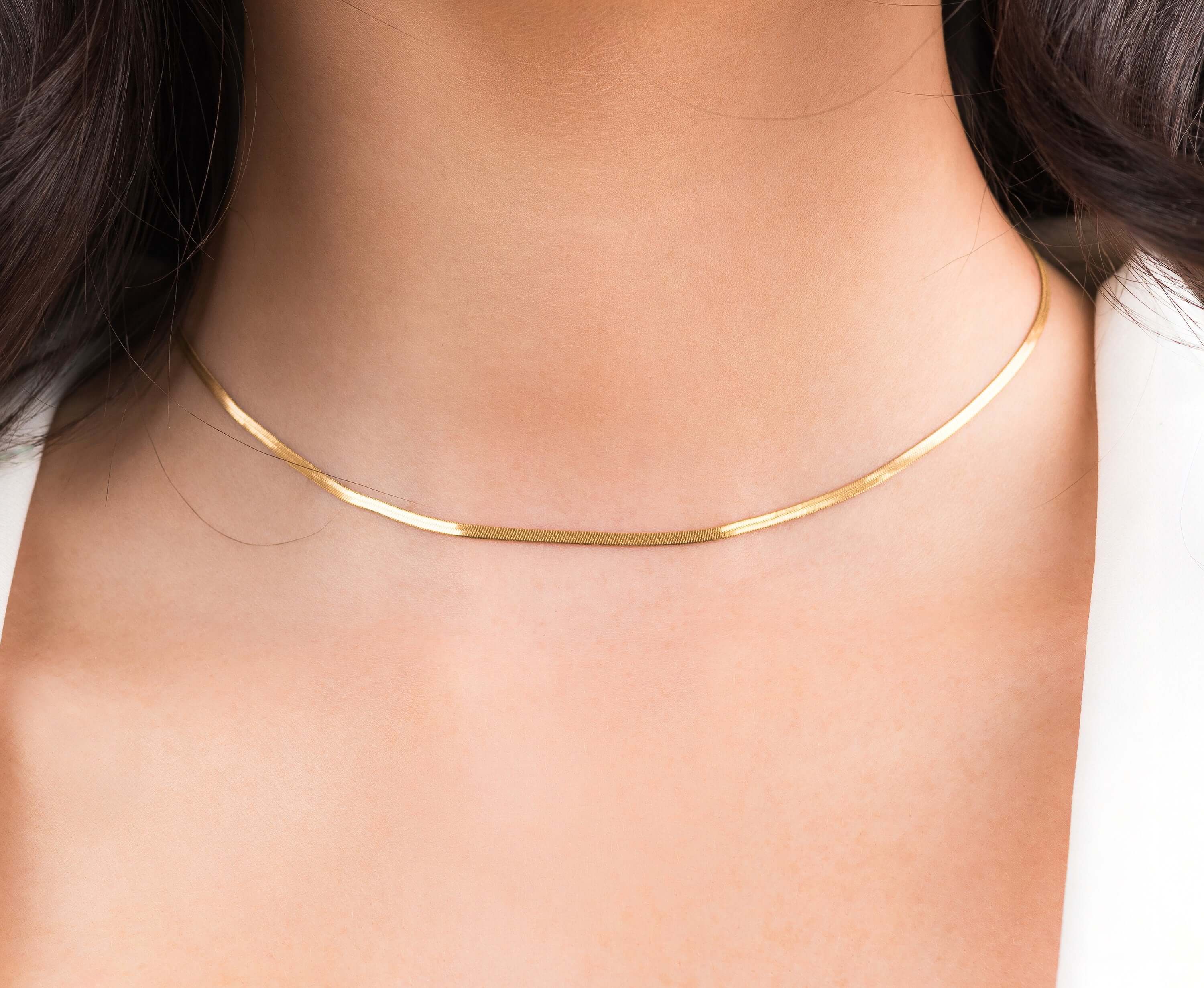 Ayla Herringbone Chain Necklace in Gold worn elegantly, showcasing its sleek design and high-quality gold-plated finish.