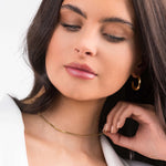 Model wearing the Ayla Herringbone Chain Necklace in Gold, showcasing its sleek elegance and layered texture.
