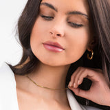 Model wearing the Ayla Herringbone Chain Necklace in Gold, showcasing its sleek elegance and layered texture.