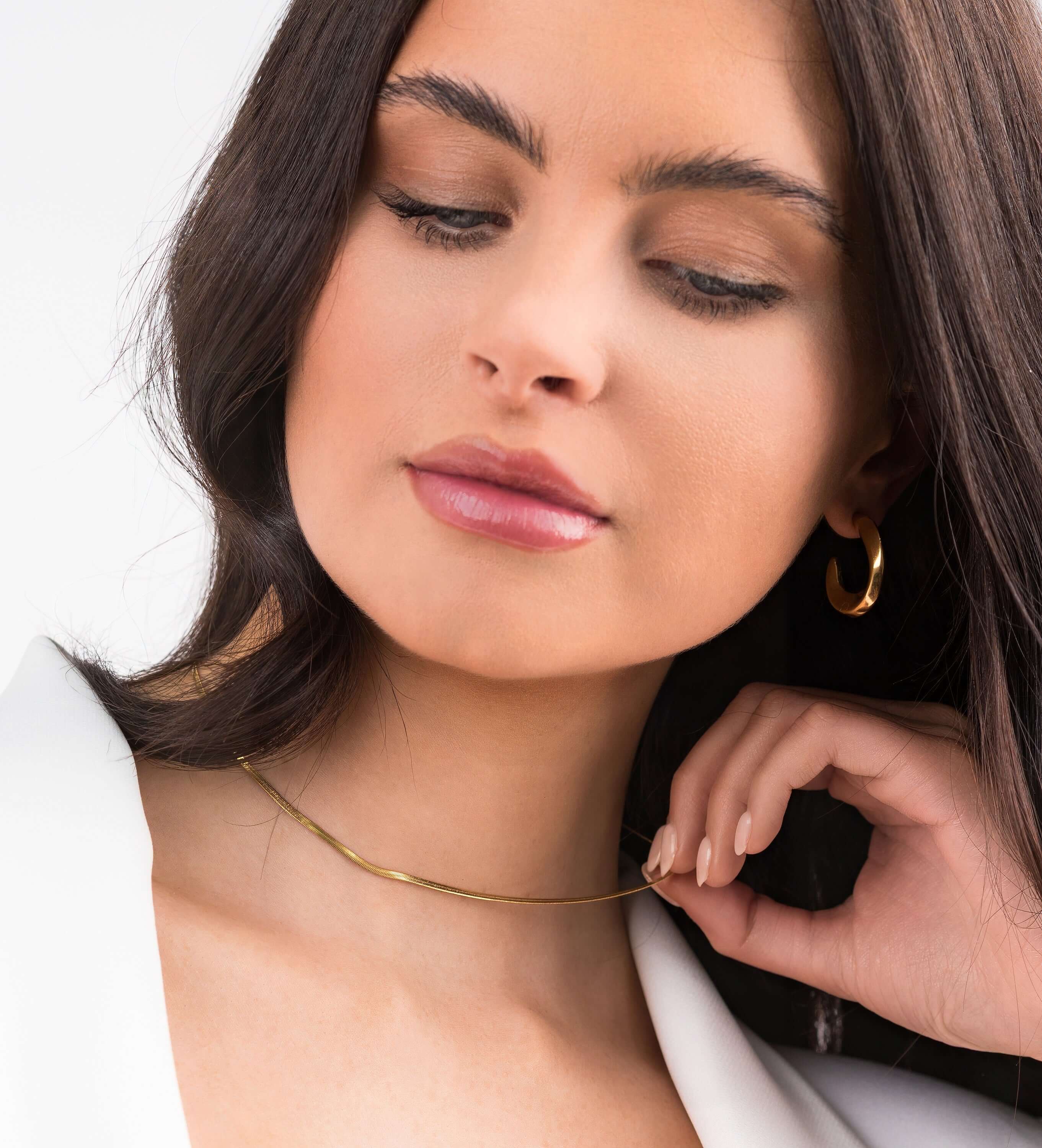 Model wearing the Ayla Herringbone Chain Necklace in Gold, showcasing its sleek elegance and layered texture.