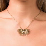 Elara Radiant Sunburst Pendant Necklace with crystal detail, symbolizing clarity and power, worn close to the heart.
