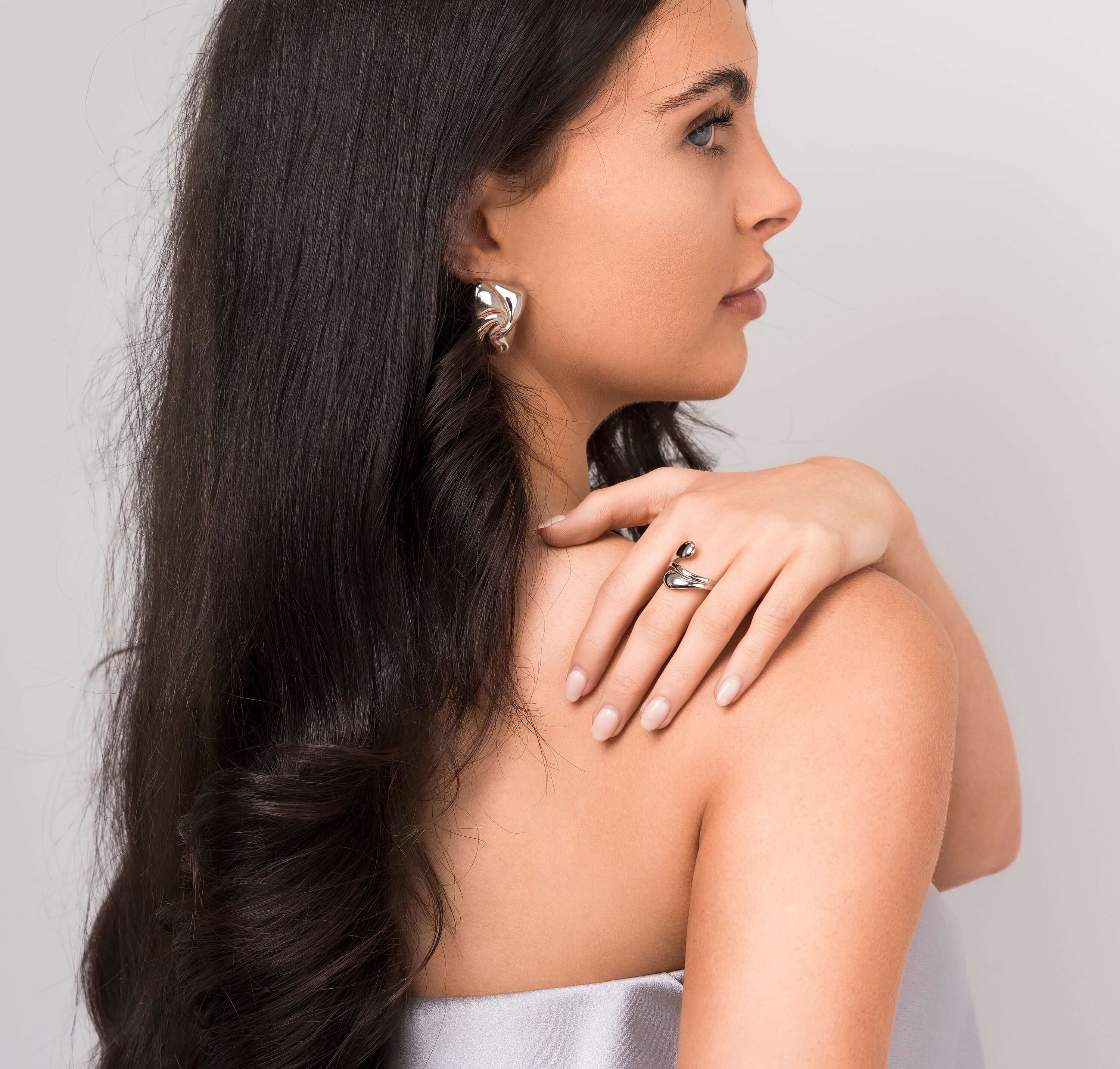 Model displaying Agnes Water Drop Adjustable Ring, showcasing its elegant and fluid design alongside statement earrings.