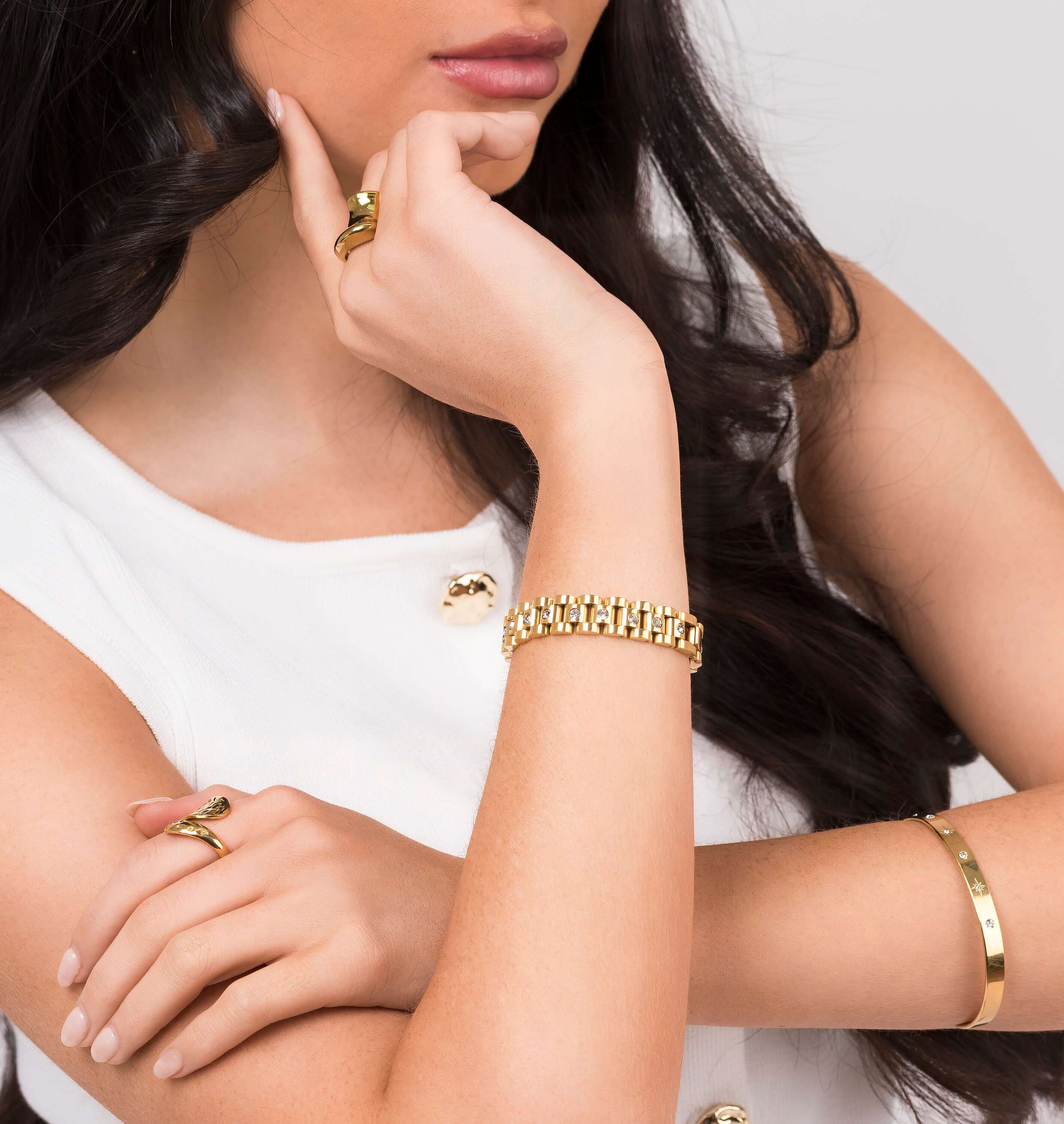 Model wearing the Raisa Sculpted Link Bracelet with crystal insets, showcasing stylish gold jewelry.