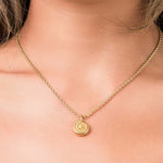 Gold rope chain necklace with spiral medallion pendant, symbolizing elegance and energy.