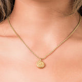 Gold rope chain necklace with spiral medallion pendant, symbolizing elegance and energy.