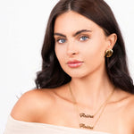 Elegant woman wearing Ediza double layer name necklace with gold finish, featuring 'Ariira' in stylish fonts.