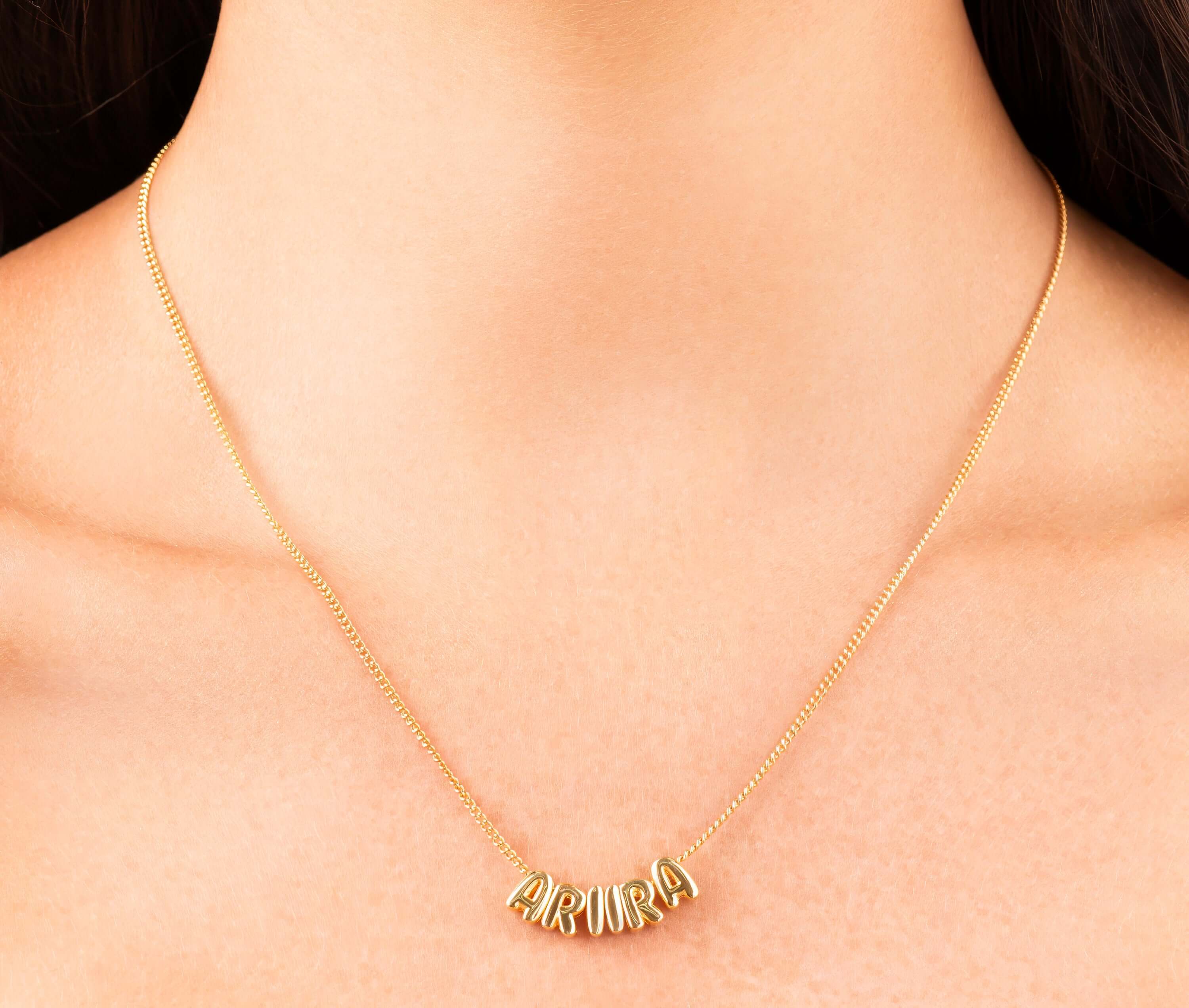 Lana Bubble Font Name Necklace in gold featuring the name ARIIRA, showcasing playful, inflated letter design.